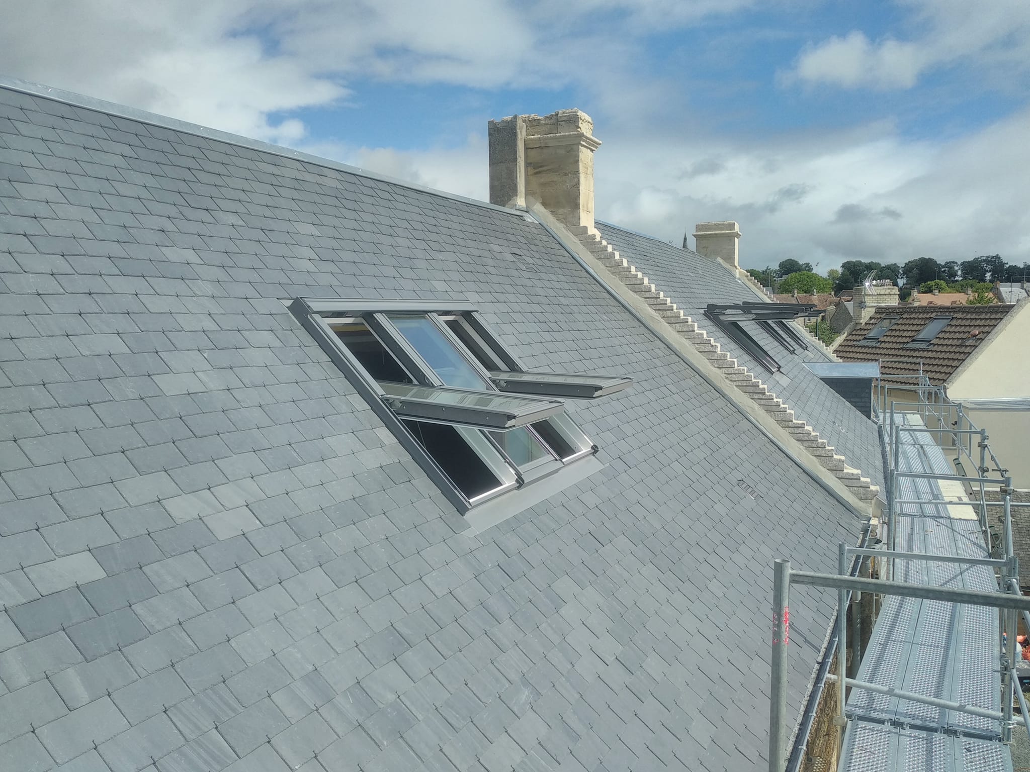 Vue sur la toiture rénovée d'une maison traditionnelle près de Bayeux.