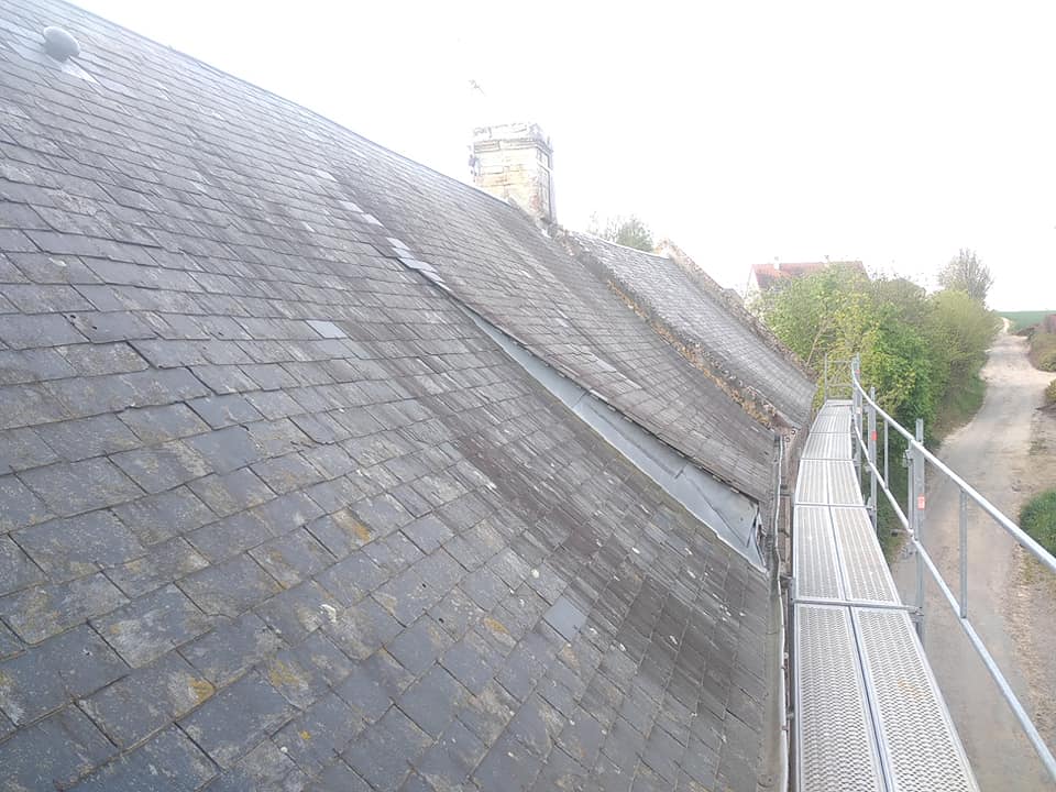 Façade est du toit en ardoises à rénover sur une maison traditionnelle près de Bayeux.